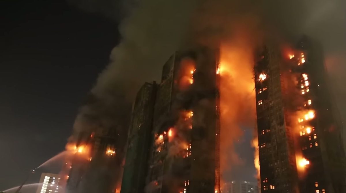 Photo of Wang Fuk Court apartment complex on fire. Water hoses are seen spraying the burning building. 