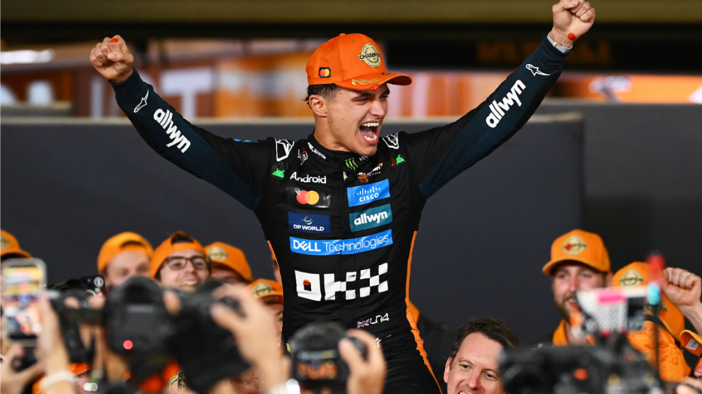 Lando Norris celebrates winning the F1 World Championship at the Abu Dhabi Grand Prix. McLaren Formula 1 Team workers are seen cheering him on. 